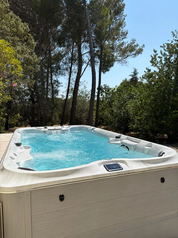 Spa Jacuzzi® encastré sur une terrasse au milieu des pins